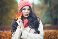 Autumn beauty. Cheerful woman with fall maple leaf