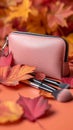 Autumn beauty essentials Pink leather clutch, makeup brushes, and leaves