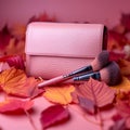 Autumn beauty essentials Pink leather clutch, makeup brushes, and leaves