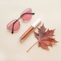 Autumn beauty or fashion composition Ã¢â¬â bronze lip gloss  and pink sunglasses. Fall makeup concept Royalty Free Stock Photo