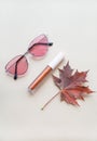 Autumn beauty or fashion composition Ã¢â¬â bronze lip gloss  and pink sunglasses. Fall makeup concept Royalty Free Stock Photo