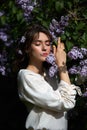 Autumn beauty portrait of a beautiful girl in the lilac branches at sunset. Lifestyle woman with natural makeup in nature with Royalty Free Stock Photo