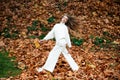 Autumn beauty. Woman fashion wodel with fall maple leaf outdoorsy, full length in motion. Autumnal vogue.