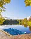 Empty boats are at the pier. Colorful autumn landscape. The sky and trees are reflected in the water of the lake Royalty Free Stock Photo