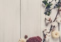 Autumn border of dried flowers on white wood, background