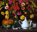 Autumn bouquet of plums raspberries pumpkin and tea dishes on the table Royalty Free Stock Photo