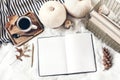 Autumn breakfast in bed composition. Blank open notepad, diary mockup. Cup of coffee, white pumpkins, plaid, oak leaves