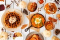 Autumn breakfast or brunch buffet table scene against a white wood background. Top view.