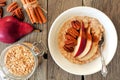 Autumn breakfast scene, oatmeal with red pear, pecans and cinnamon