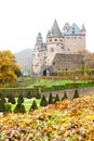 Autumn Burresheim Castle with topiary green trees in ornamental
