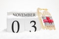 Autumn calendar made of wooden cubes with the date of November 3, the concept of the first snow and future holidays. Close-up Royalty Free Stock Photo