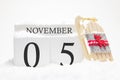 Autumn calendar made of wooden cubes with the date of November 5, the concept of the first snow and future holidays. Close-up Royalty Free Stock Photo