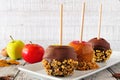 Autumn candy apples with chocolate and caramel against white wood