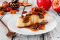 Autumn caramel apple pecan cheesecake, close up side against white wood