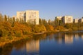 Autumn city landscape mirrored in the river with yellow and orange trees on its bank