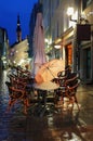 Autumn city pink umbrella  rainy season  street cafe cup of coffee on table   old town of Tallinn panorama blurring bokeh city nig Royalty Free Stock Photo