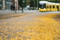 Autumn city scene blurred background. Blurred street, tram and yellow foliage in Berlin. Royalty Free Stock Photo