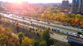 Autumn city street with traffic and parking lots, aerial view