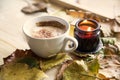 Autumn coffee cup with candle and dried leaves decorations on wooden table, cozy fall deco concept Royalty Free Stock Photo