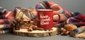 Autumn coffee cup with candle, spices and blanket decorations on wooden board, cozy fall deco concept, home sweet home