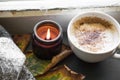 Autumn coffee and scented candle window setting, cozy fall inter