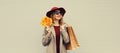 Autumn color style outfit, beautiful elegant happy lady woman with shopping bag holds yellow maple leaves wearing hat and coat Royalty Free Stock Photo