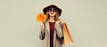 Autumn color style outfit, beautiful elegant happy lady woman with shopping bag holds yellow maple leaves wearing hat and coat Royalty Free Stock Photo