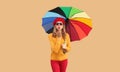 Autumn color style outfit, beautiful young woman posing with colorful umbrella blowing her lips sends kiss wearing red french Royalty Free Stock Photo