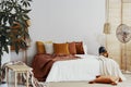 Autumn colored pillows on king size bed in chic bedroom interior