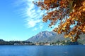 Autumn colorful foliage in red and yellow color over lake with beautiful mountain landscape on Lake Como, Italy Royalty Free Stock Photo