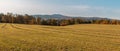 Autumn colorful tree foliage on meadow, and hill Klet. Czech landscape Royalty Free Stock Photo