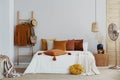 Autumn colors in bright natural bedroom with wooden accents, copy space on empty wall Royalty Free Stock Photo