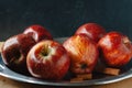 Autumn colors. Red apples with some cinnamon sticks on a steel tray on black backgraund. Chiaroscuro. space for text Royalty Free Stock Photo