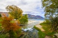 Autumn colours at Lake Wanaka in Central Otago region of New Zealand, river stream, lake and hills at the background Royalty Free Stock Photo