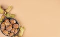 Autumn composition.Bowl with shelled hazelnuts on beige background with copy space.