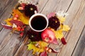 Autumn composition - coffee, maple leaves and flowers on wooden background. Seasonal autumn concept with drink.