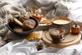 Autumn composition with a cup of coffee, cookies and candles in bed. Royalty Free Stock Photo