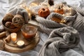 Autumn composition with a cup of coffee, cookies and candles in bed. Royalty Free Stock Photo