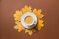 Autumn composition, fall leaves, hot steaming cup of coffee on brown background Royalty Free Stock Photo