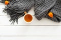 Autumn composition. Feminine desk table with knitted scarf, tea cup, dry flowers on wooden white background. Flat lay, top view. Royalty Free Stock Photo