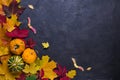 Autumn composition. Frame made of different multicolor dried leaves and pumpkin on dark background. Autumn, fall concept. Flat lay