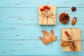 Autumn composition and gifts on blue background. Pattern made of autumn leaves, acorn, pine cones
