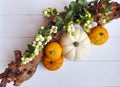 An autumn composition of gourd pumpkins, white berries and a branch