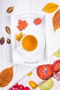 Autumn composition. Herbal tea, autumn leaves and gingerbread in the form of maple leaf and acorn on a white background