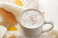 Autumn composition with hot coffee, a warm scarf and yellow leaves on a white wooden table Royalty Free Stock Photo