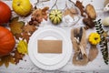 Autumn composition on an old wooden table with a plate and cutlery Royalty Free Stock Photo