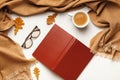 Autumn composition. Open inverted book glasses cashmere scarf, coffee cup with autumn leaves on a white background. Royalty Free Stock Photo