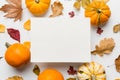 Autumn composition with paper blank and dried leaves with pumpkin on table. Flat lay, top view, copy space Royalty Free Stock Photo