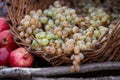 Autumn composition of pomegranates and a basket of grapes at the farmer\'s market