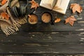 Autumn composition. Two cups of coffee, sugar, scarf, headphones, open book, maple leaves on black wooden background Royalty Free Stock Photo